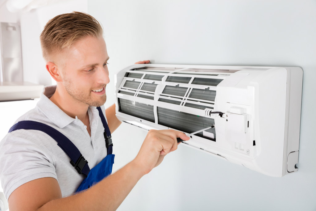 HVAC technician cleaning and repairing a ductless mini split AC in Glendale, AZ