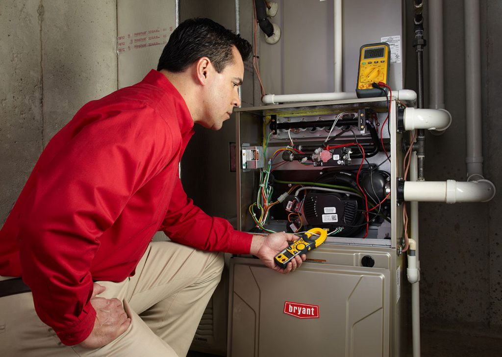 Heating and air conditioning technician servicing an indoor furnace in Glendale, AZ