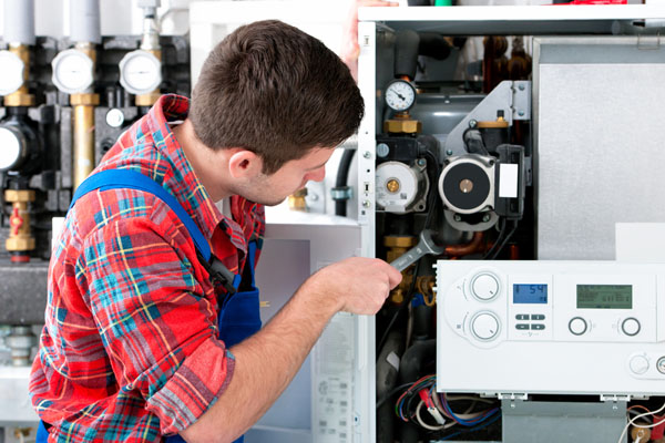 HVAC technician inspecting an indoor heating system in Glendale, AZ
