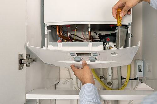 HVAC technician repairing an indoor boiler in Glendale