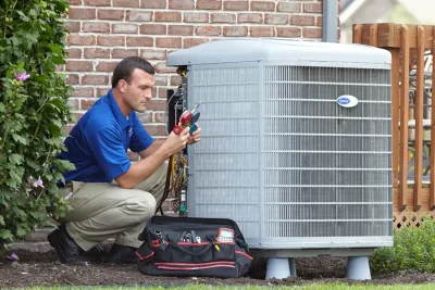 HVAC technician inspecting an outdoor air conditioning unit in Glendale, AZ