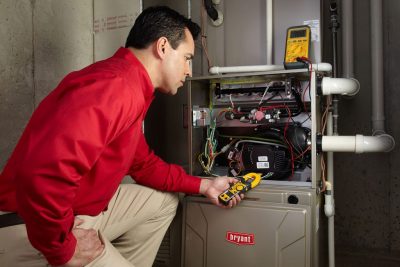 Heating and air conditioning technician servicing an indoor furnace in Glendale, AZ
